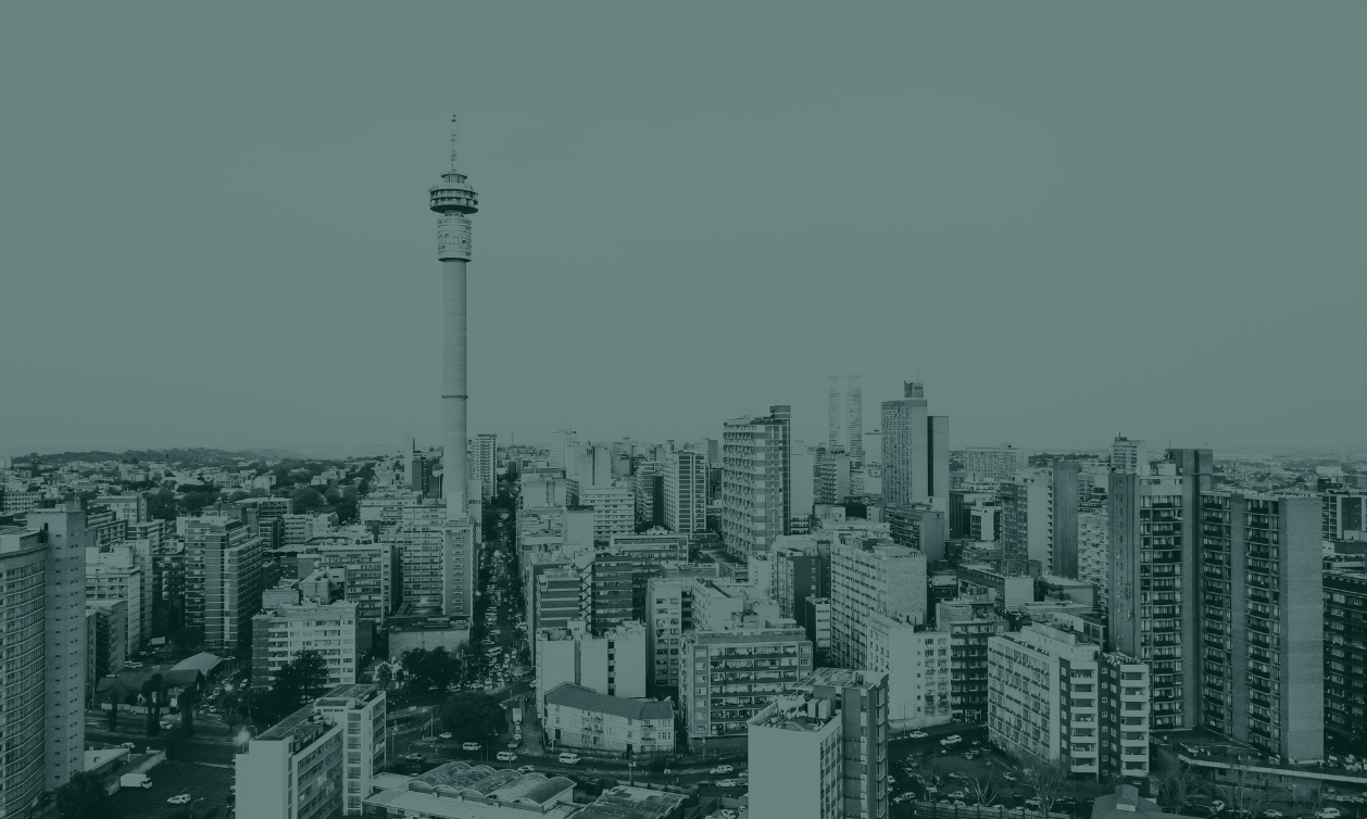 A cityscape view of Johannesburg, featuring high-rise buildings and the iconic Johannesburg Tower.