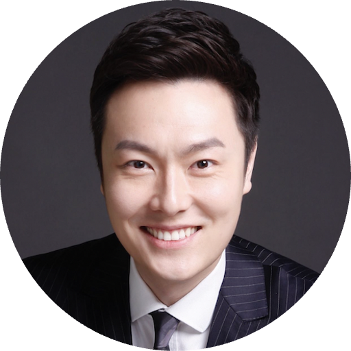 Allen Zhou Thunes.com Professional headshot: smiling man in a dark pinstripe suit and white shirt against a gray background.